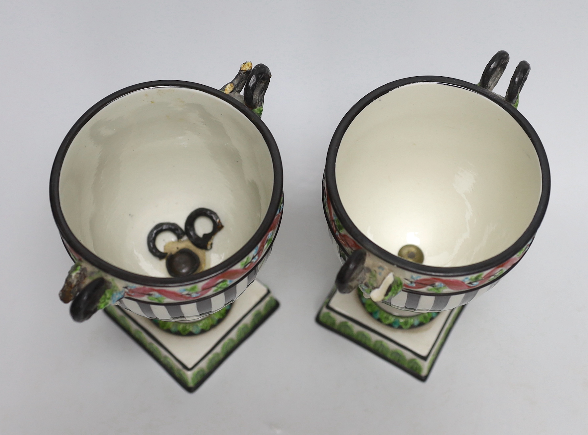 A pair of Wedgwood urns with twin handles and acorn design knops, each 22cm high